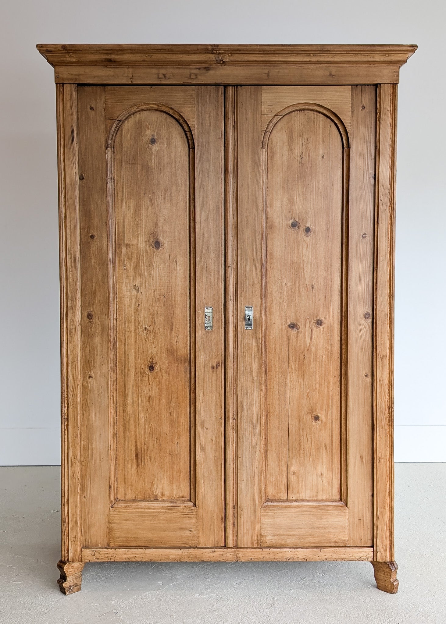 Handsome Antique European Pine Cabinet with Arched Panel Doors, Carved Feet and Skeleton Key